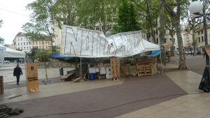 17 hzurzq : la petite agora qui voisine la place Guichard à Lyon est déserte. Quelques jeunes sont déjà là et ont posé banderoles, stand et petits châpiteaux... (© Pierre Nouvelle). 